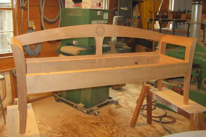 Wooden bench frame in a workshop setting.