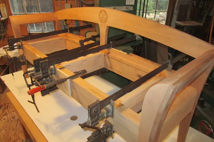 Woodworking project with clamps in workshop.