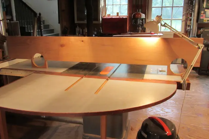 Woodworking table with lamp and circular saw.