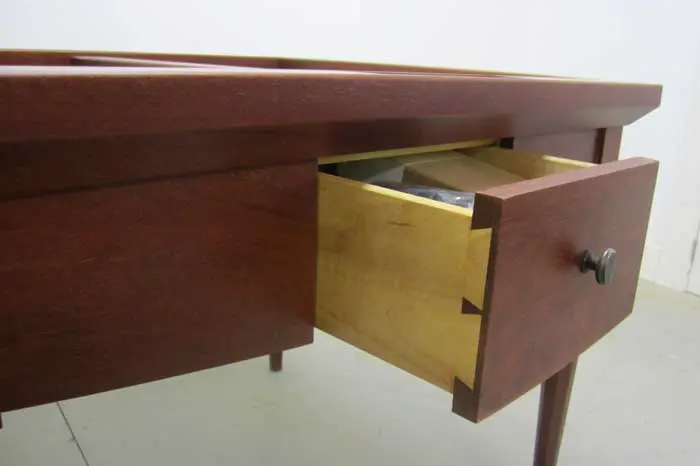 Wooden desk with open drawer.