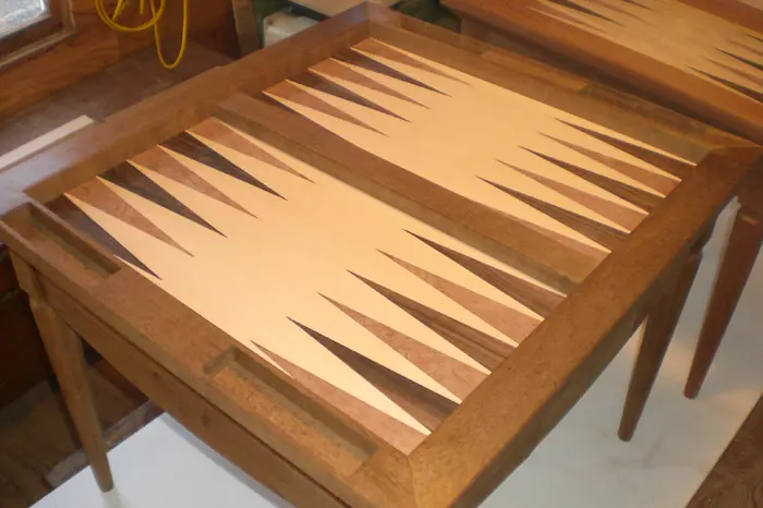 Wooden backgammon table with inlaid board design.