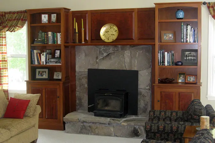 Living room with fireplace and wooden shelves.