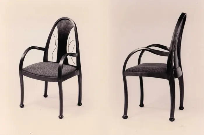 Two elegant black chairs, front and side.