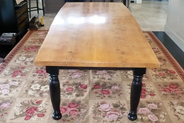 Wooden table on floral-patterned rug.