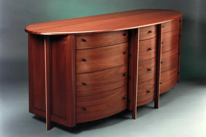 Elegant wooden dresser with curved design.
