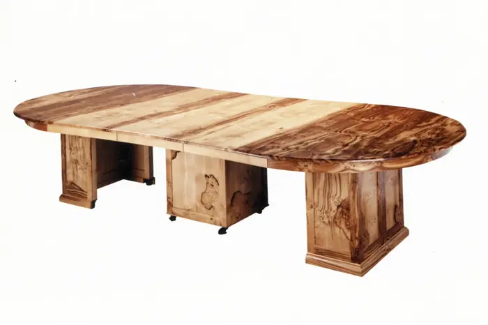 Wooden oval dining table with pedestal base.