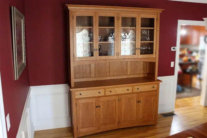 Wooden hutch against a red wall.