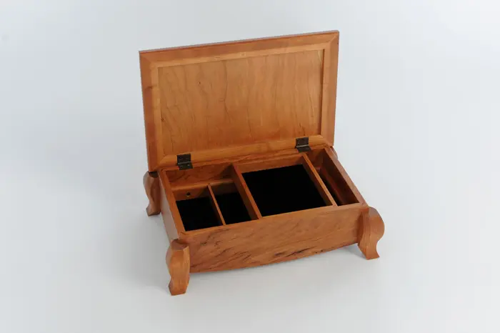 Open wooden jewelry box with compartments.