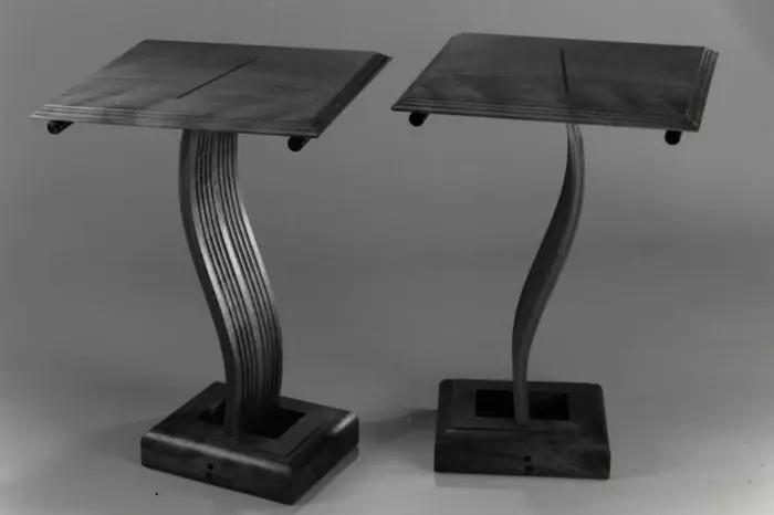 Wooden tables with curved, artistic bases.