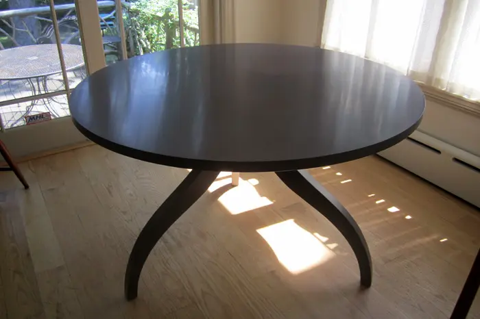 Round table with curved legs by window.