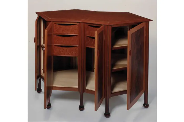 Wooden corner cabinet with open doors.