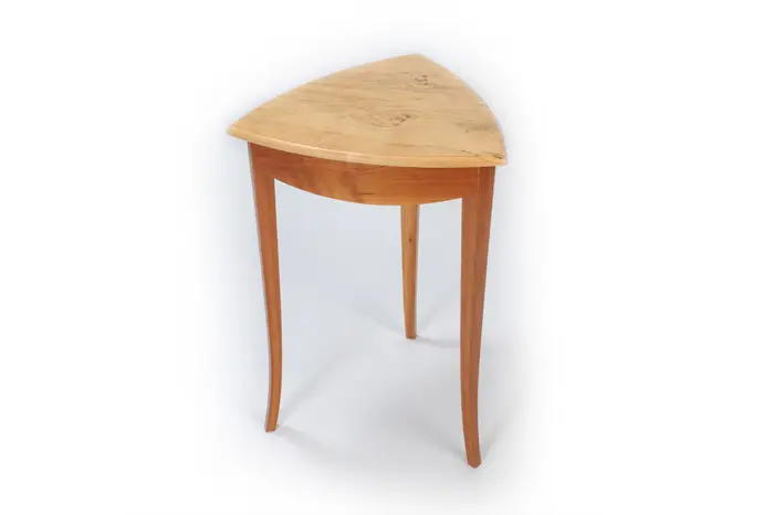 Triangular wooden table with three legs.