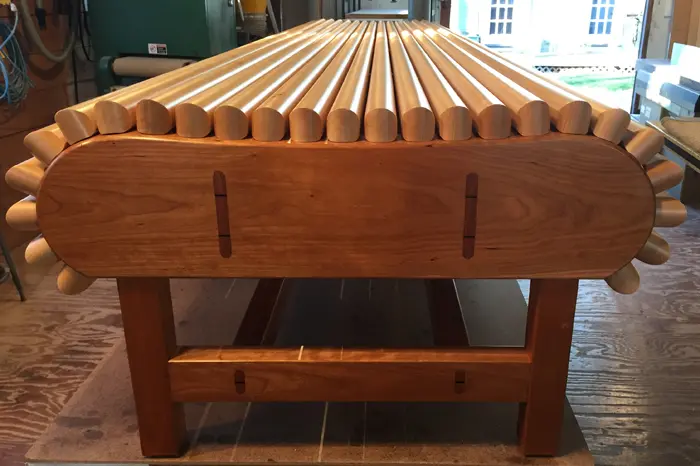 Wooden bench with rounded wooden slats.